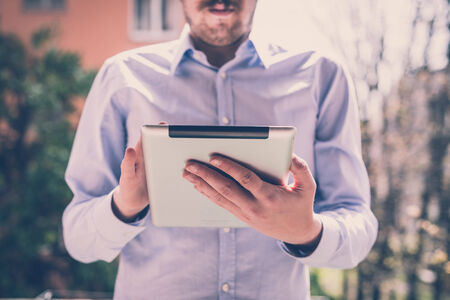 close up hands multitasking man using tablet connecting wifiの写真素材