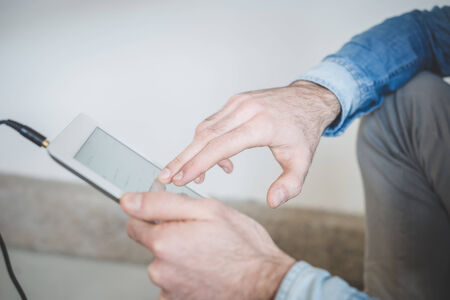 close up of man hands using tablet outdoorsの写真素材