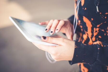 close up of woman hands using tablet outdoorsの写真素材