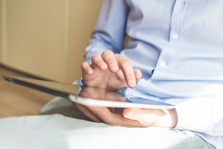 close up hands multitasking man using tabletの写真素材