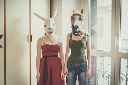 mask rabbit and horse mask lesbian couple at homeの写真素材