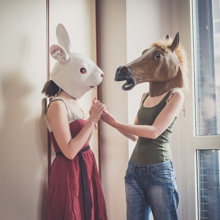 mask rabbit and horse mask lesbian couple at homeの写真素材