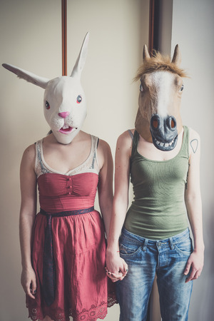 mask rabbit and horse mask lesbian couple at homeの写真素材