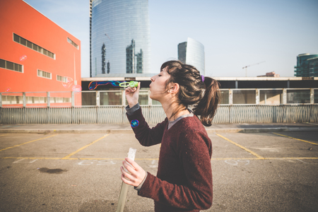 young beautiful hipster woman bubble blower in the cityの写真素材
