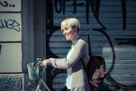 beautiful young blonde short hair hipster woman witk bike in the cityの写真素材
