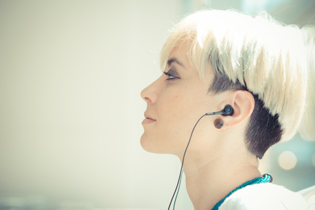 beautiful young blonde short hair hipster woman at the cafeの写真素材
