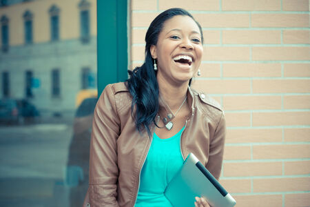 beautiful african young woman using tablet in the cityの写真素材