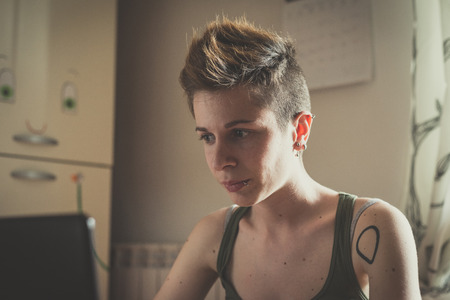 young lesbian stylish hair style woman using notebook at home の写真素材