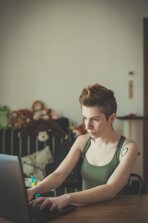 young lesbian stylish hair style woman using notebook at home の写真素材