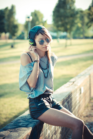 young beautiful model woman listening music in the cityの写真素材