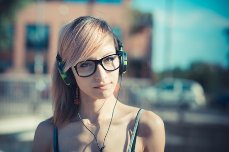 young beautiful model woman listening music in the cityの写真素材