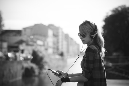 young beautiful model woman listening music in the cityの写真素材