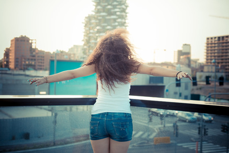 young beautiful long curly hair hipster woman in the cityの写真素材