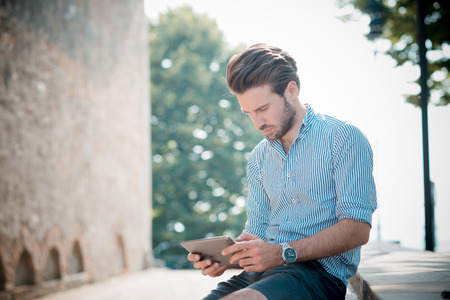young handsome hipster modern man outdoor using tablet in summertimeの写真素材