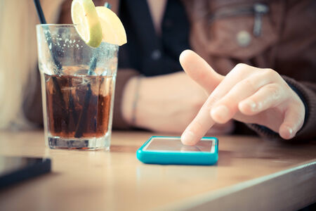 close up of woman hands using smart phones at the bar の写真素材