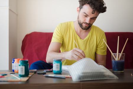 handsome hipster modern man painting at home