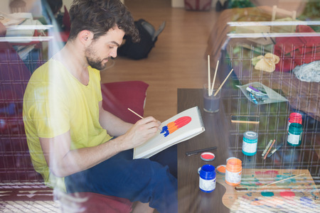 handsome hipster modern man painting at home