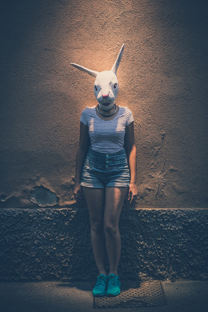 young hipster woman with rabbit mask in the cityの写真素材