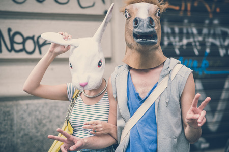 horse and rabbit mask couple of friends young  man and woman in the cityの写真素材