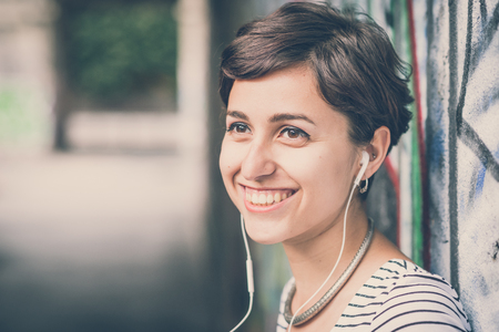 young hipster woman listening to music in the cityの写真素材