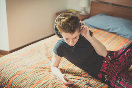 young lesbian stylish hair style woman listening to music at homeの写真素材