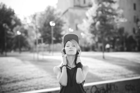 young beautiful model woman listening music in the city