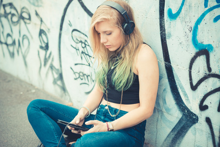 beautiful young blonde hair woman hipster listening music in the cityのeditorial素材
