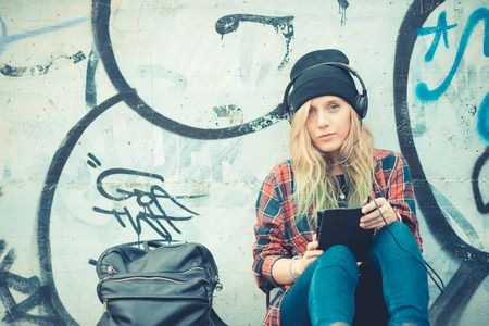beautiful young blonde hair woman hipster listening music in the cityのeditorial素材