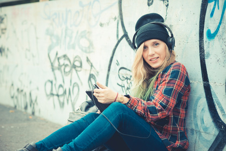 beautiful young blonde hair woman hipster listening music in the cityのeditorial素材