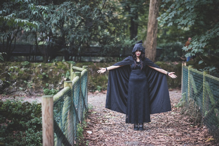 beautiful dark vampire woman with black mantle and hood halloweenの写真素材