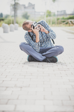 handsome hipster casual multitasking modern man with vintage camera in the cityの写真素材