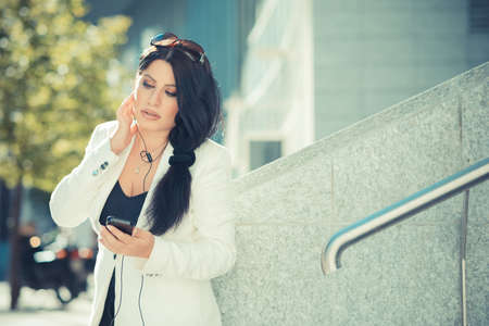 beautiful long black hair elegant business woman using smartphone  in the cityの写真素材