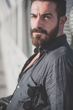 young handsome attractive bearded model man in urban contextの写真素材
