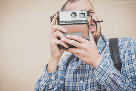 handsome hipster casual multitasking modern man with vintage camera in the cityの写真素材