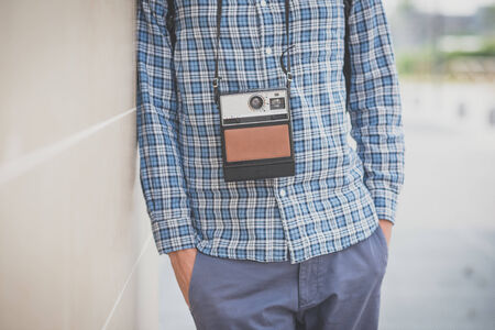handsome hipster casual multitasking modern man with vintage camera in the cityの写真素材
