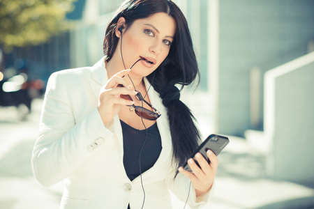 beautiful long black hair elegant business woman using smartphone  in the cityの写真素材