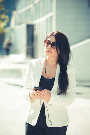 beautiful long black hair elegant business woman using smartphone  in the cityの写真素材