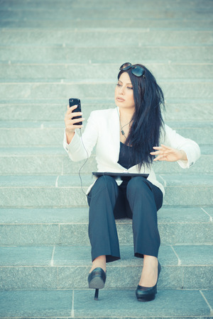 beautiful long black hair elegant business woman using smartphone in the cityの写真素材