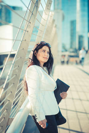 beautiful long black hair elegant business woman with tablet  in the cityの写真素材