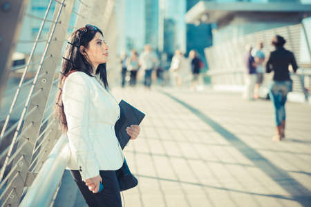 beautiful long black hair elegant business woman with tablet  in the cityの写真素材