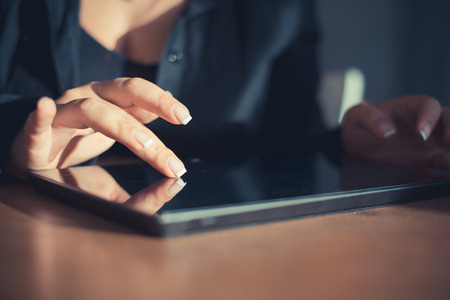close up of woman hand using tablet indoorの写真素材