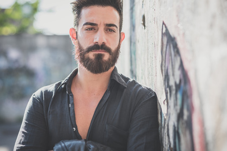 young handsome attractive bearded model man in urban contextの写真素材