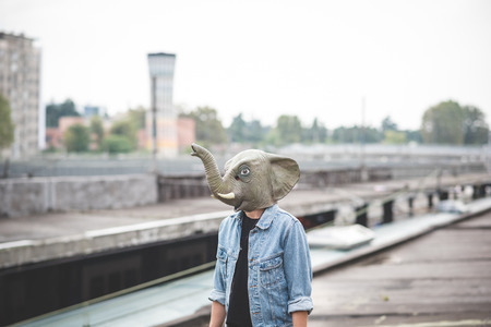 elephant mask young handsome bearded hipster man in the city