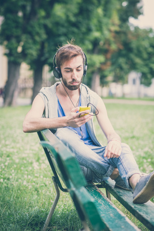 young hipster gay man listening music headphones in the cityの写真素材