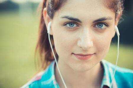 beautiful young hipster woman listening music in the cityの写真素材