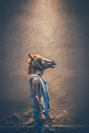 horse mask young hipster gay man in the cityの写真素材