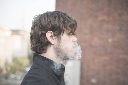 young handsome blonde italian violinist smoking cigaretteの写真素材