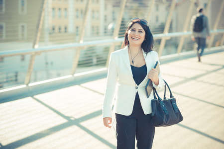 beautiful long black hair elegant business woman with tablet  in the city