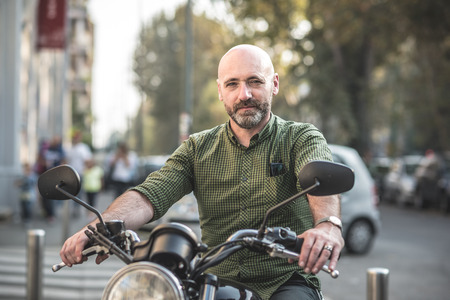 handsome middle aged man motorcyclist in the cityの写真素材