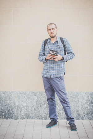 handsome hipster casual multitasking modern man with vintage camera in the cityの写真素材